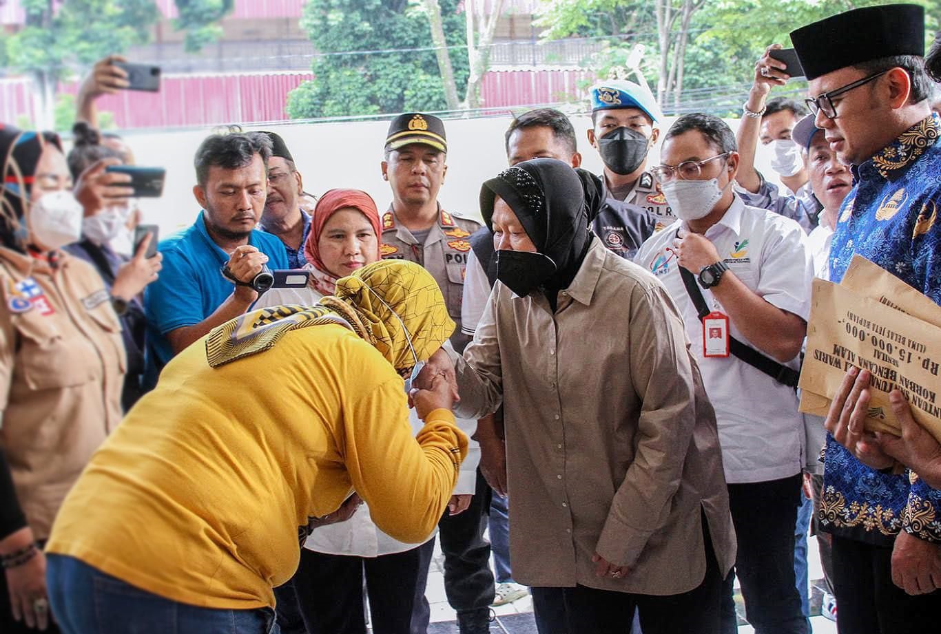 Menteri Sosial (Mensos) Tri Rismaharini didampingi Wali Kota Bogor Bima Arya saat menyerahkan santunan kepada ahli waris korban bencana tanah longsor di Kelurahan Kebon Kelapa, Kota Bogor. (Yudha Prananda / Jabar Ekspres)