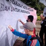 Jarnas Beraksi Jabar membentangkan spanduk yang ditanda tangani oleh para pendukung Capres Anies Baswedan di Lapangan Sempur, Kota Bogor, Minggu (9/10). (Yudha Prananda / Jabar Ekspres)