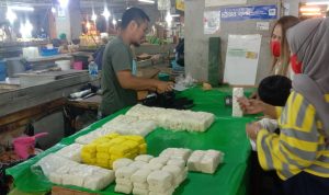 JUAL MAHAL: Oki (43) salah seorang pedagang tahu tempe di Pasar Kosambi Bandung yang kini sudah menaikkan harga jualnya, Senin (17/10).