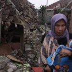 HINDARI GEMPA: Seorang ibu sambil mengendong anaknya yang masih bayi, tampak lari menghindari gempa di Cianjur, Senin 21 November 2022. (SANDIKA FADILAH/JABAREKPRES.COM)