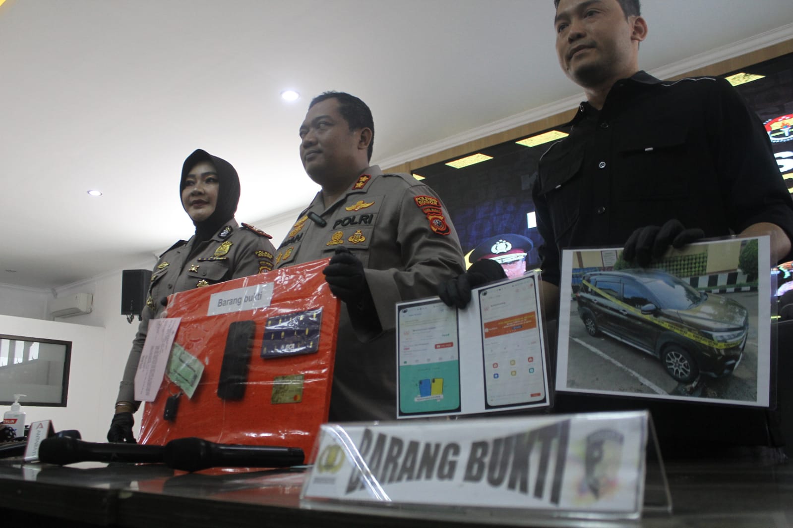 AMANKAN BARANG BUKTI: Polisi saat menunjukkan barang bukti dugaan penipuan dengan modus pinjaman online (pinjol) terhadap ratusan mahasiswa IPB di Mako Polres Bogor. (SANDIKA FADILAH/JABARESKPRES.COM)