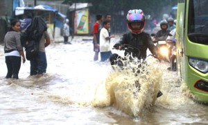 Tips aman berkendara motor bila harus menerjang banjir