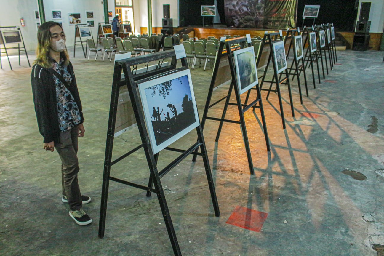 Seorang pengunjung pameran tengah menyimak foto jurnalistik hasil karya anggota WFB. (KHOLID/JABAR EKSPRES)
