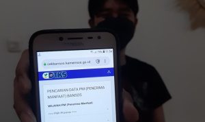 KUNJUNGI WEBSITE: Seorang warga Kota Bandung saat menunjukkan website resmi kemensos untuk mendapatkan saldo dana dari pemerintah seperti BPNT. (Hendrik Alonso/Jabar Ekspres)