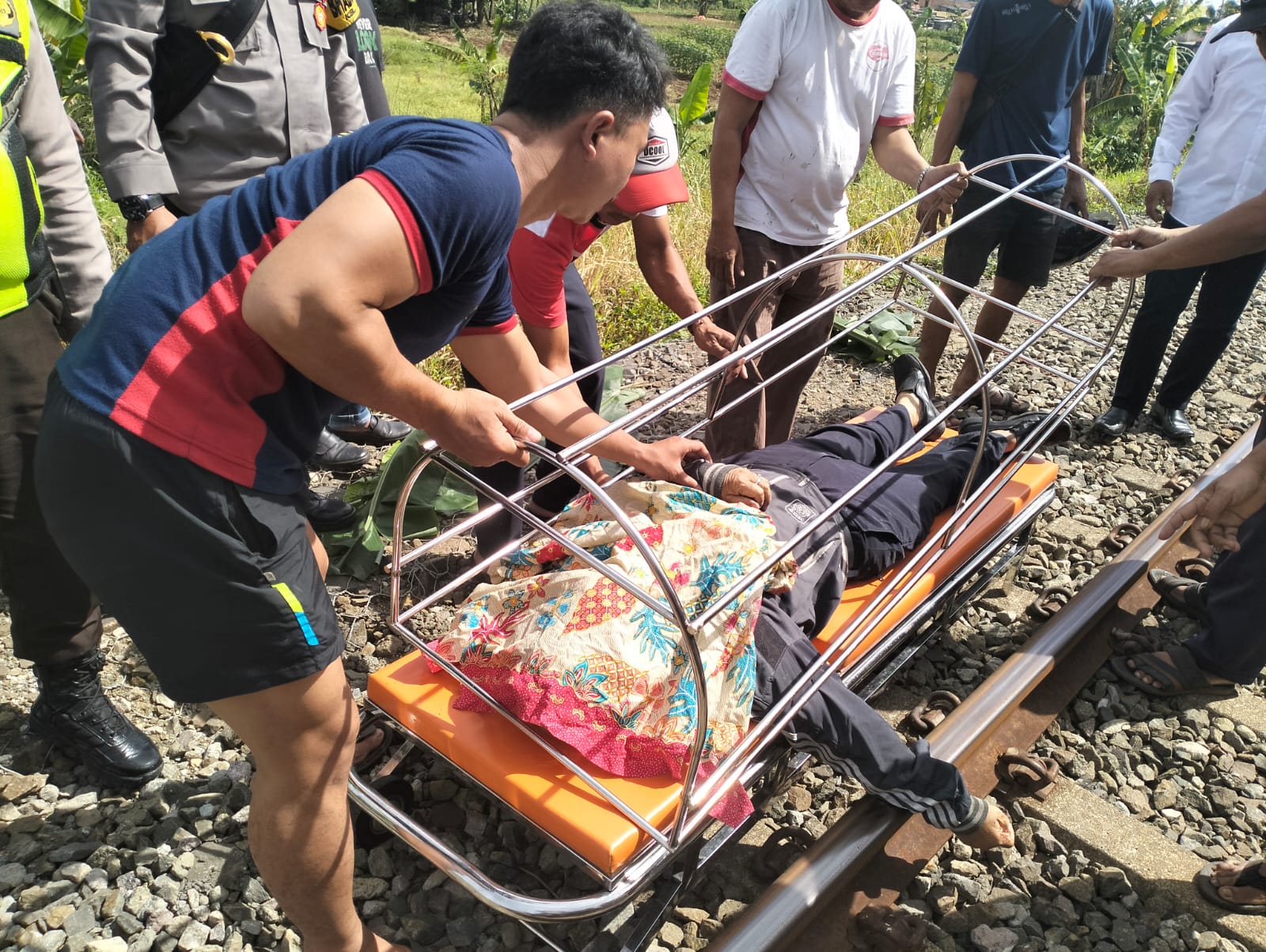 Warga bersama petugas saat mengevakuasi korban meninggal dunia di perlintasan kereta api Pondok Rajeg, Kabupaten Bogor. (Sandika Fadilah via Polsek Cibinong)