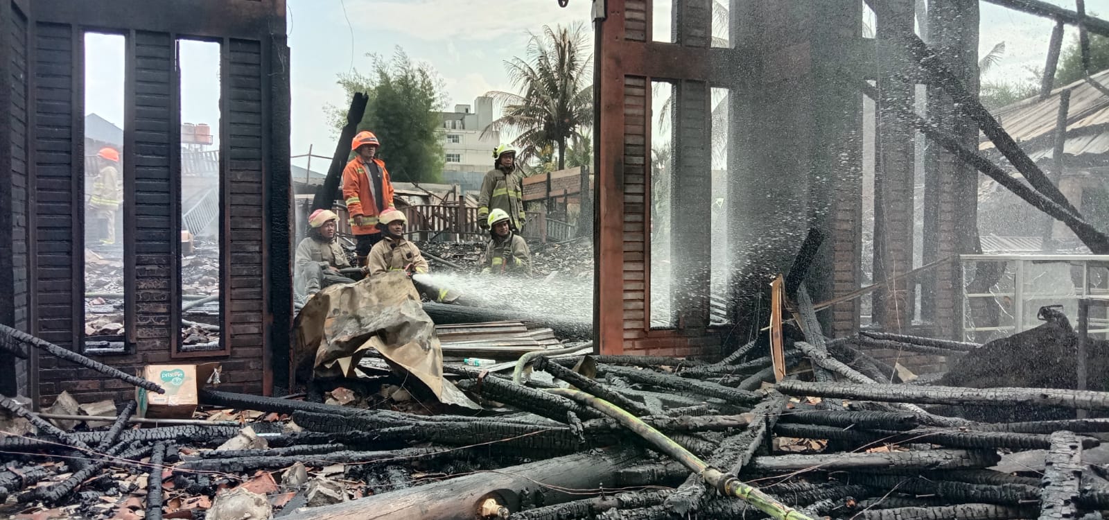 Petugas pemadam kebakaran saat melakukan pendinginan di Rumah Makan Ampera Soekarno-Hatta, Kamis (12/1/2023). (Sandi Nugraha/Jabar Ekspres)