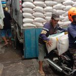Salah seorang tengah memindahkan karung beras untuk ketersediaan di Bandung. (SANDI NUGRAHA/JABAR EKSPRES)