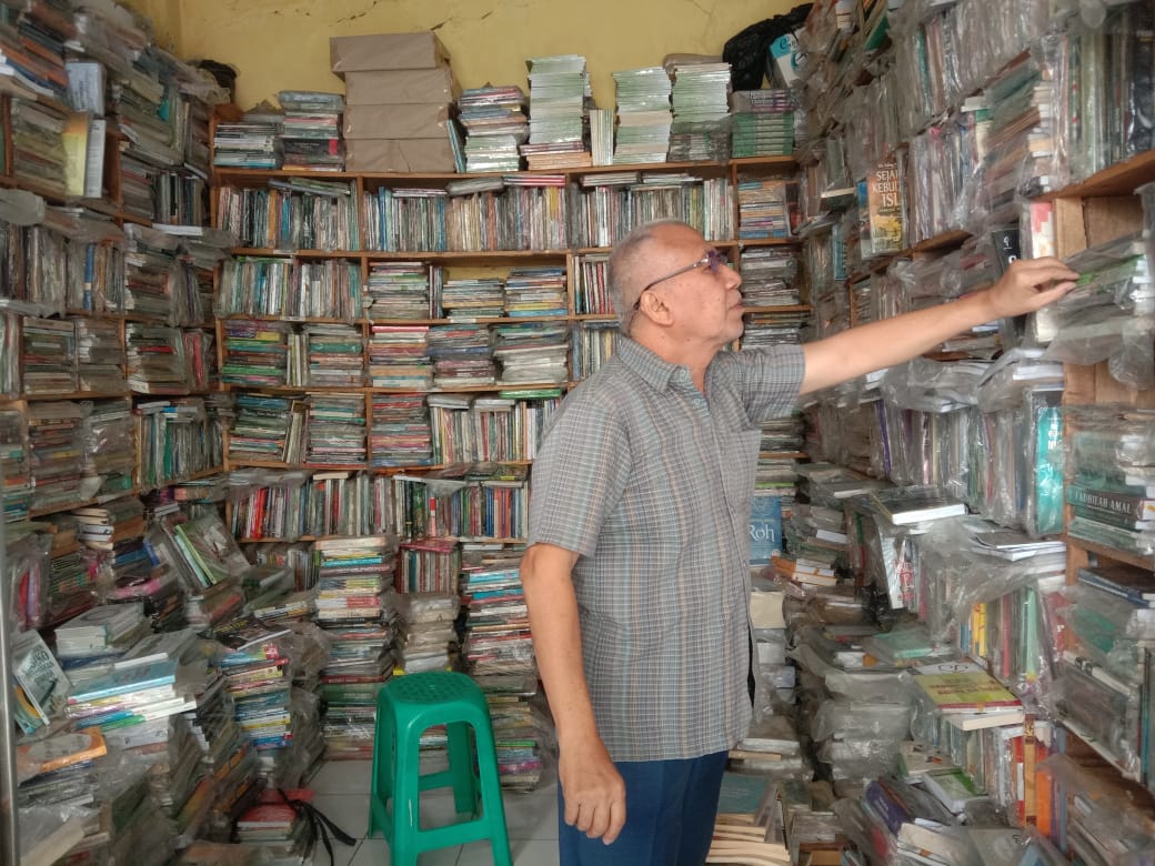 Salah seorang pemilik toko buku, Iqro tampak merapikan buku-buku koleksinya dan bisa dibaca secara gratis. Diketahui, minat baca masyarakat sangat rendah. (FAHMINAH/JABAR EKSPRES)