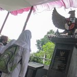 BUKTI SEJARAH: Tiga anak sekolah dasar tengah menghadap Tugu Pancasila yang bergengker di makam Inggit Garnasih di TPU Caringin Porib, Kecamatan Babakan Ciparay, Kota Bandung. (KHOLID/JABAR EKSPRES)