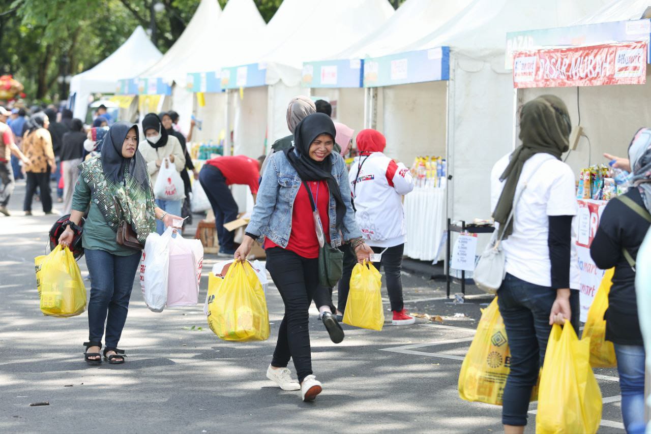 SENANG RIA: Seorang warga sambil membawa barang belanjaan tampak sumringah usai belanja di pasar mudah Bandung.