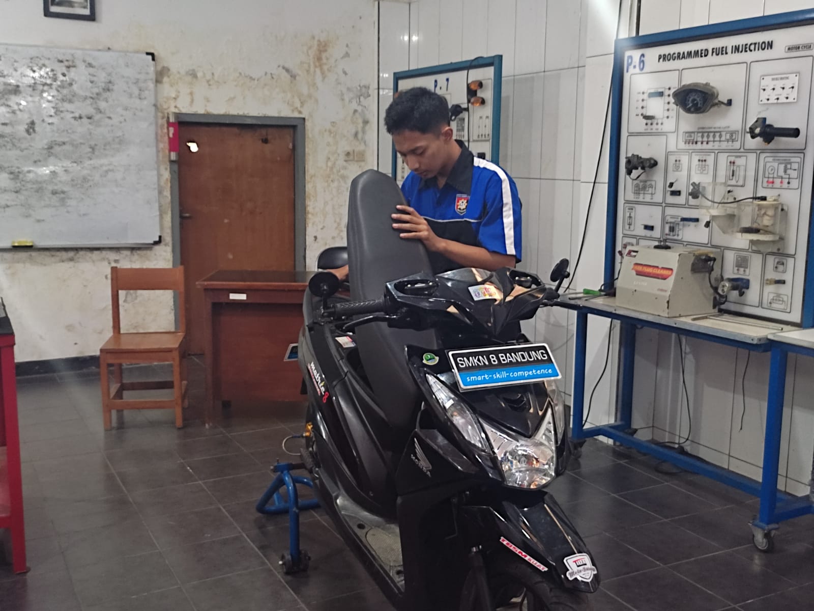 HASIL MODIFIKASI: Arya,16, salah satu siswa yang berpartisipasi dalam pengerjaan motor listrik di SMKN 8 Bandung. (Sadam Husen/Jabar Ekspres)