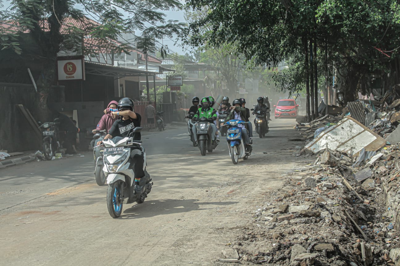 Kepulan debu akibat penertiban pedagang oleh Satpol PP Kota Bandung di pinggiran kampus ISBI menutupi pandangan pengendara. (KHOLID/JABAR EKSPRES)