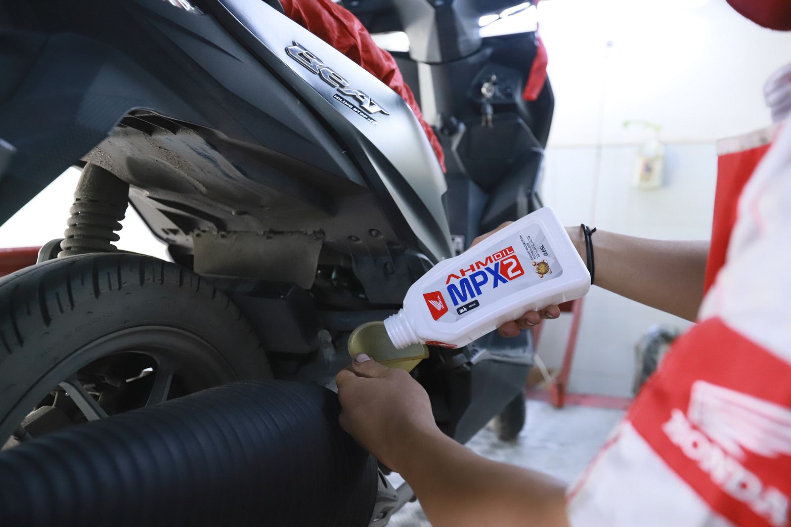 Teknisi AHASS melakukan penggantian pelumas sepeda motor Honda menggunakan AHM OIL MPX2 dengan ukuran 0,65L.