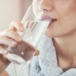 Potret wanita sedang mengonsumsi air putih