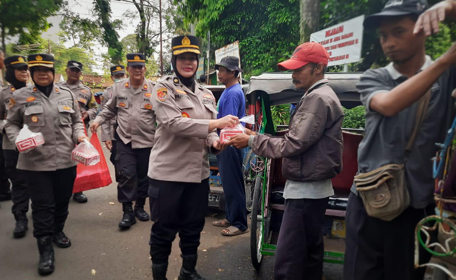 Jajaran Polresta Bogor Kota saat membagikan paket takjil buka puasa kepada sejumlah tukang becak disekitar Polsek Bogor Barat, Kamis (13/4). (Yudha Prananda / Jabar Ekspres)