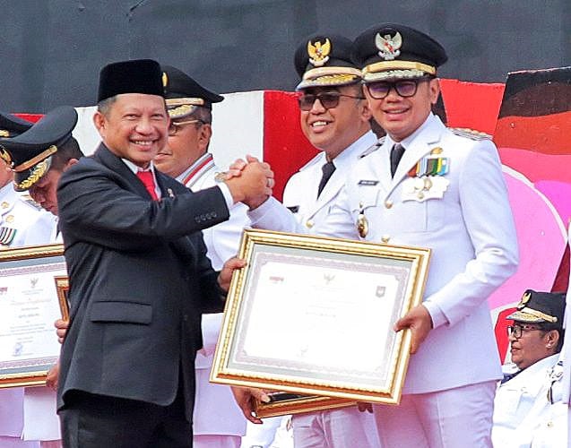 RAIH PRESTASI: Mendagri Tito Karnavian saat menyerahkan penghargaan kepada Pemerintah Kota Bogor yang diterima oleh Wali Kota Bogor Bima Arya di Kota Makassar, Sabtu (29/4). (ISTIMEWA)