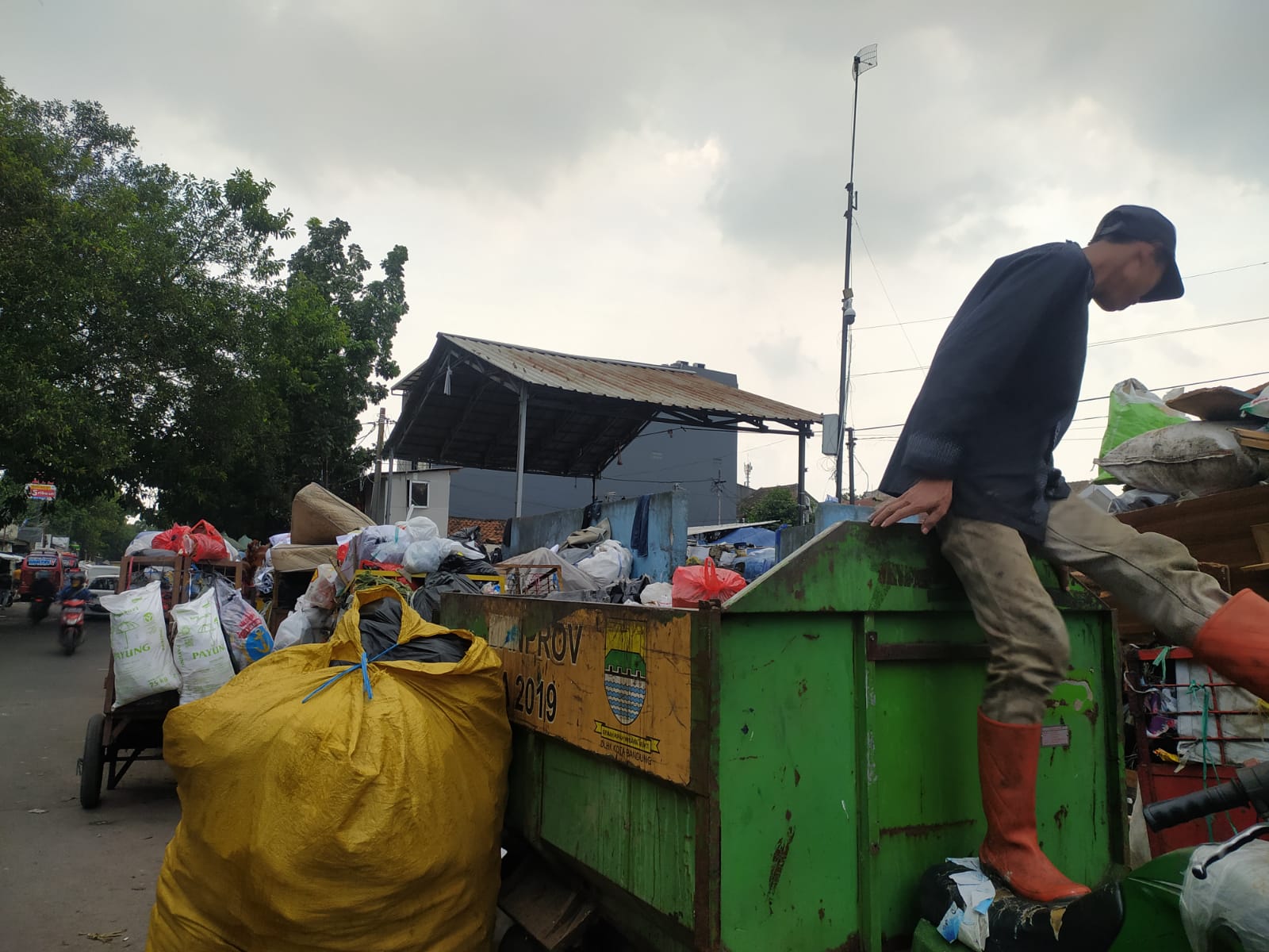 Petugas Kebersihan di TPS Pagarsih dengan tumpukan sampah yang masih berada di roda akibat kekurangan armada pengangkut sampah untuk dibawa ke TPA Sarimukti. Foto: Akmal Firmansyah/Jabarekspres.