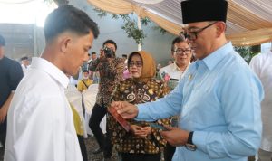 Plt Bupati Bogor Iwan Setiawan secara simbolin memberikan buku nikah kepada pasangan pengantin. Foto : Sandika Fadilah/Jabarekspres.com