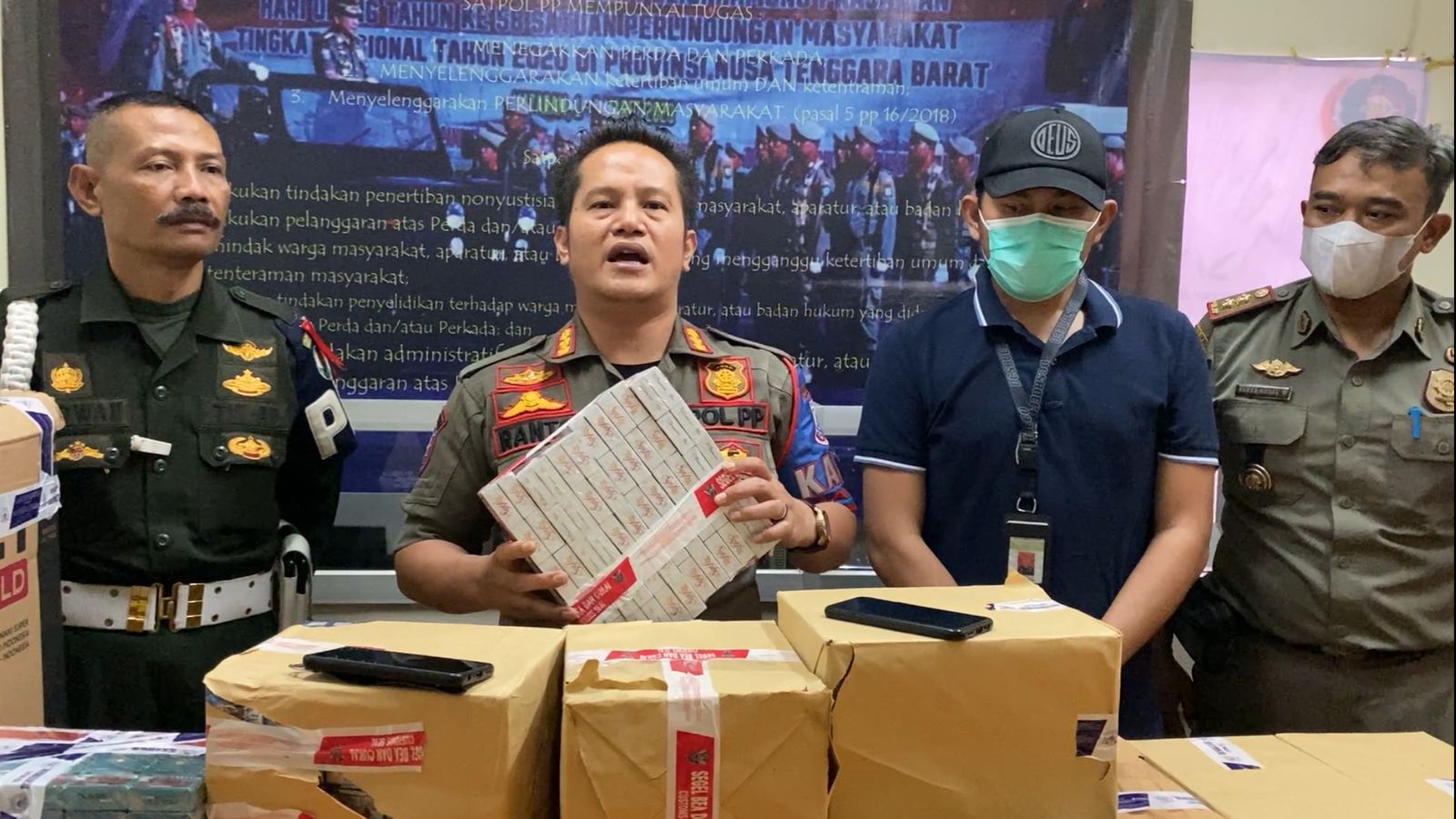 Kepala Bidang Penegakan Perda Satpol PP Kota Cimahi Ranto Sitanggang memegang rokok ilegal yang disita dari tokok kelontongan di wilayah Padasuka Kota Cimahi, Senin (12/6).