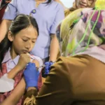 Salah satu siswa diberikan imunisasi untuk mencegah penyakit diare dan kanker mulut rahim sejak dini, Selasa (8/8).