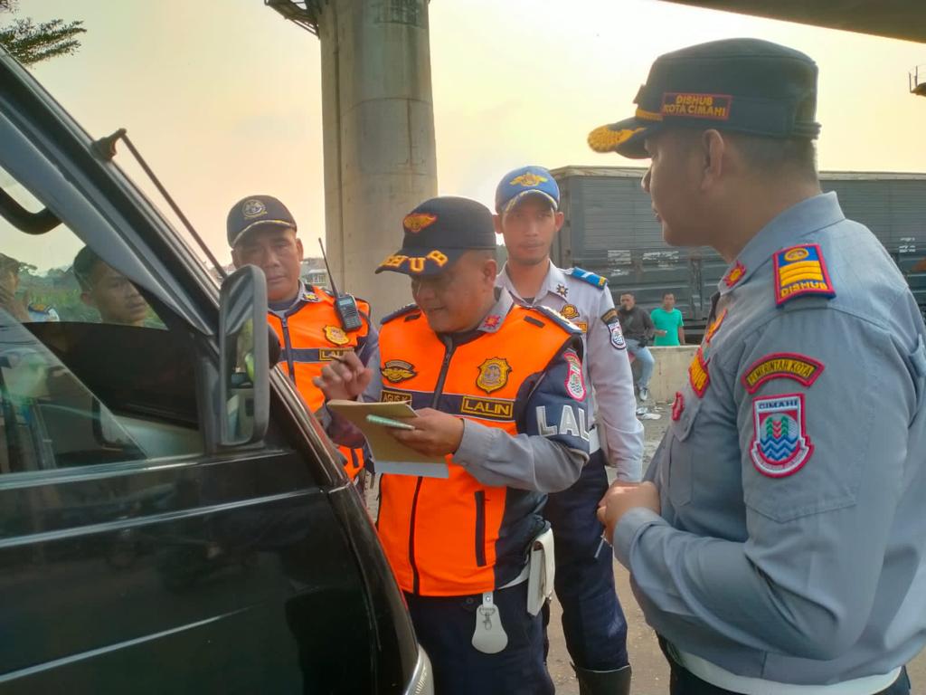 Petugas dari Dinas Perhubungan Kota Cimahi menghentikan satu unit mobil barang lantaran melanggar jam opersional kendaraan di bundaran Leuwigajah, Kota Cimahi baru-baru ini. (Foto istimewa)