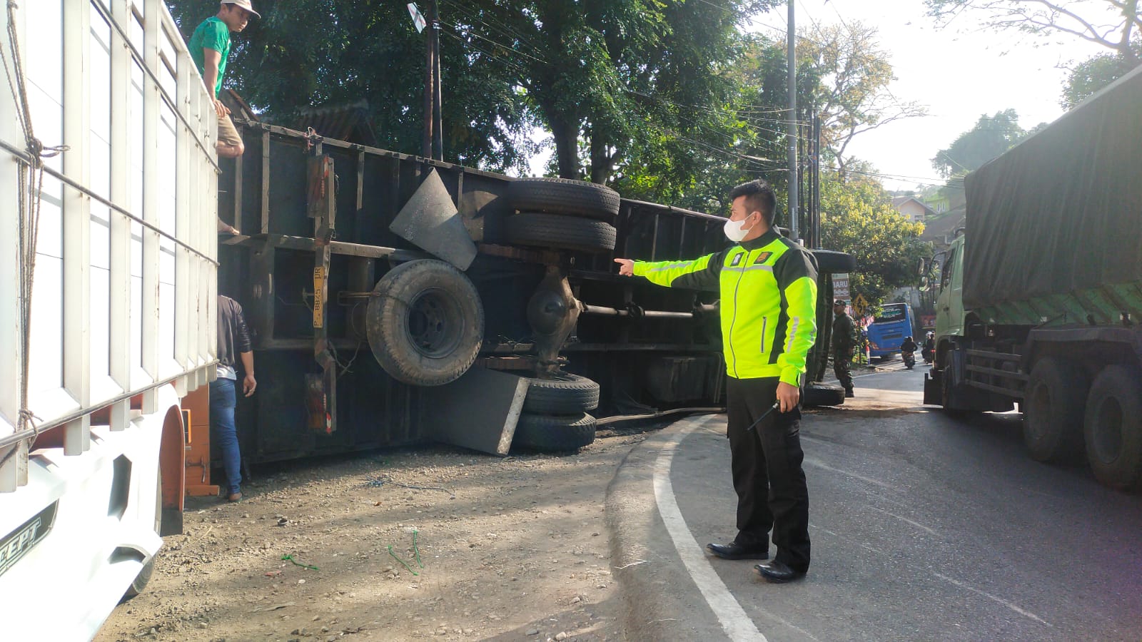 Bripka Aria Nugraha sedang menunjuk ke arah truk fuso yang mengalami kecelakaan, Rabu 23 Agustus 2023. (Je/ Dedi suhandi)
