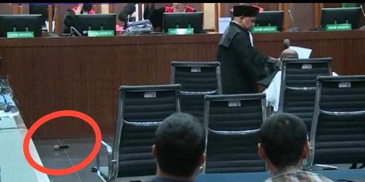 Tangkapan layar video Lukas Enembe lempar mik saat sidang kasus korupsi yang menjeratnya di persidangan Tipikor, Senin (4/9). (Youtube)