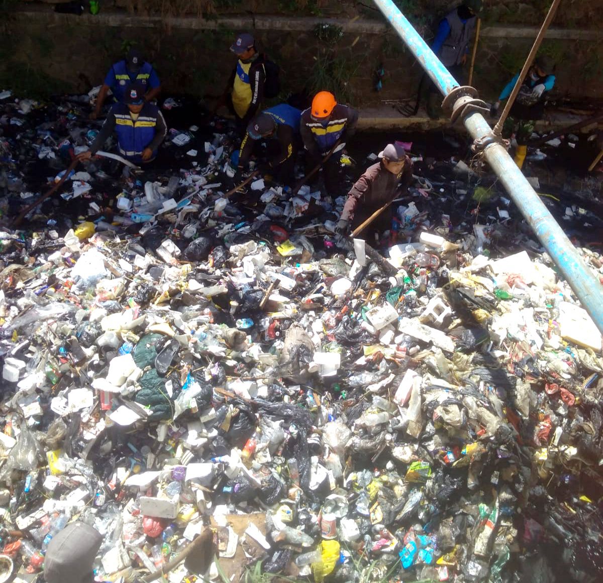 Petugas saat membersihkan sampah yang menumpuk di Sungai Cikendal Kelurahan Melong Kecamatan Cimahi Selatan baru-baru ini. (Foto: Istimewa)