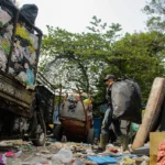 Petugas kebersihan tengah mengangkut kantong besar berisi sampah di TPS Cijambe, Kota Bandung. (Pandu Muslim/Jabarekspres)