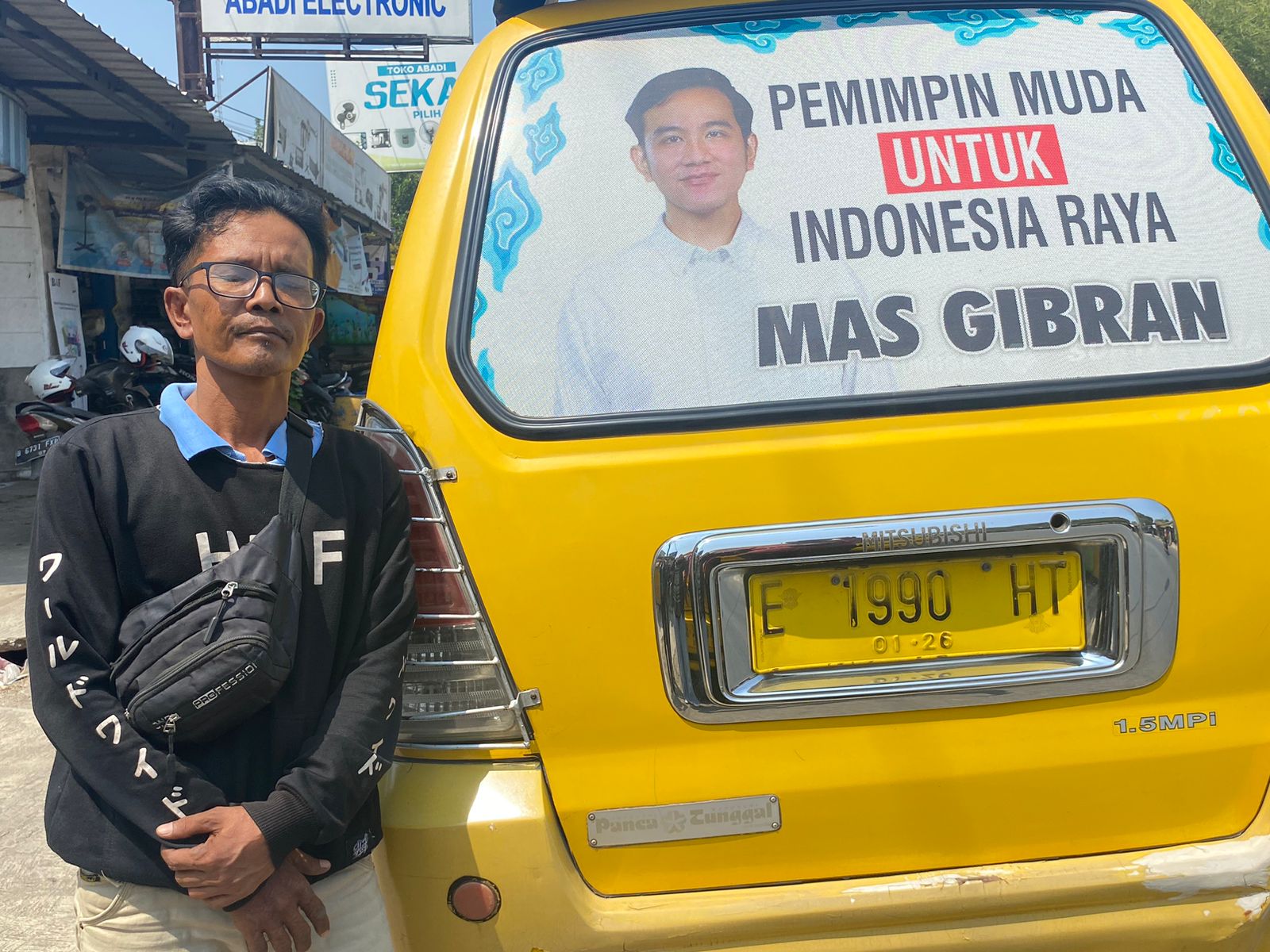 Supir angkot Cirebon, Abidi (46) bersama angkotnya bergambar Wali Kota Solo, Gibran Rakabuming. Jabar Ekspres/Ayu Lestari.