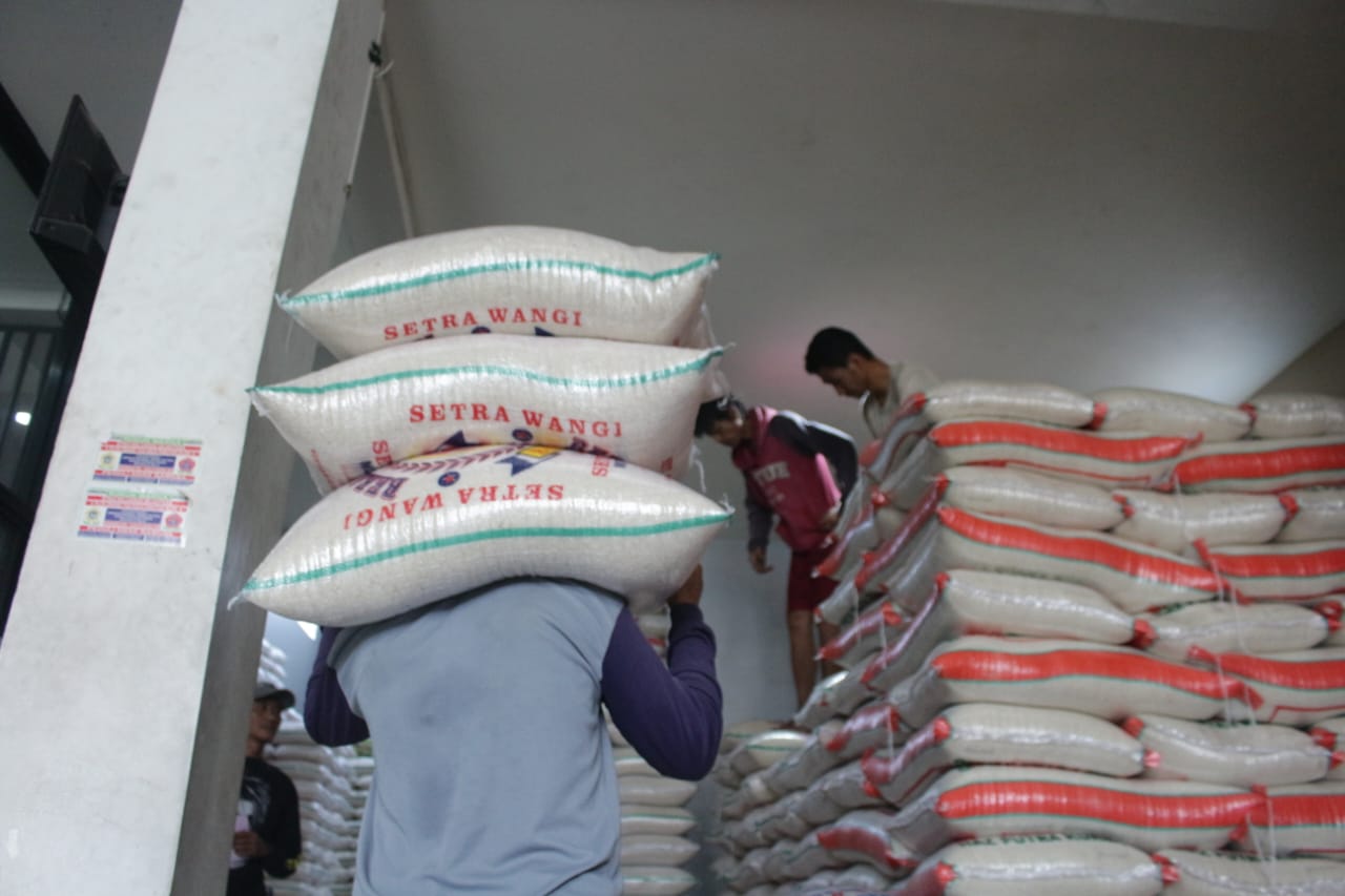 Pegawai di salah satu grosir beras tengah memanggul sejumlah karung beras, di Cibiru, Bandung. (Pandu/Jabarekspres)