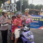 Kasatlantas Polresta Bogor Kota, Kompol Galih Apria beserta jajaran saat membagikan sabuk keselamatan kepada pengendara motor yang terjaring membonceng anak di Pos Polisi Terminal Baranangsiang, Sabtu (9/9). (Yudha Prananda / Jabar Ekspres)