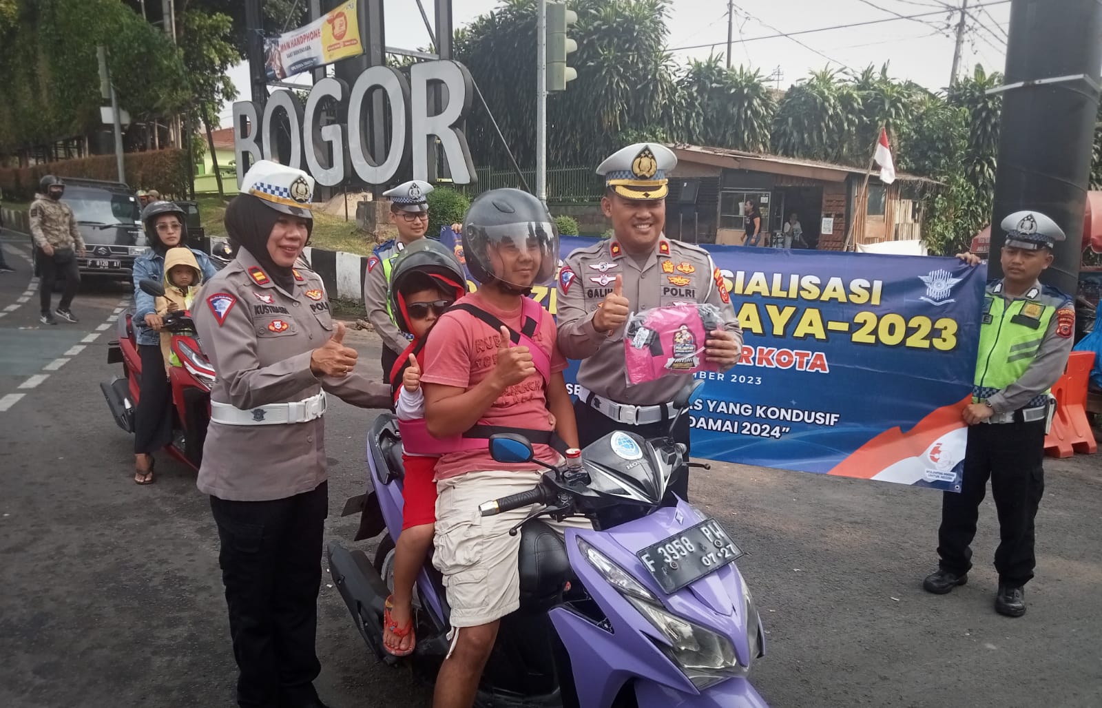 Kasatlantas Polresta Bogor Kota, Kompol Galih Apria beserta jajaran saat membagikan sabuk keselamatan kepada pengendara motor yang terjaring membonceng anak di Pos Polisi Terminal Baranangsiang, Sabtu (9/9). (Yudha Prananda / Jabar Ekspres)