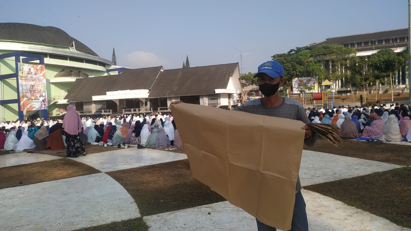 Atang (61) berjualan alas kertas saat pelaksanaan shalat Istisqa di lapang merdeka kota Sukabumi. Foto: Riki/Jabar Ekspres