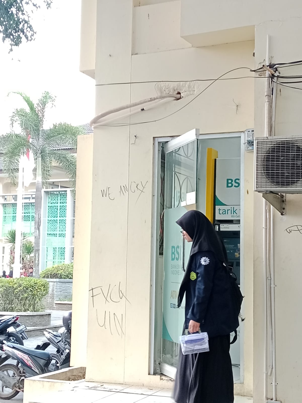 Seorang mahasiswi UIN Bandung keluar dari ATM BSI UIN Bandung.