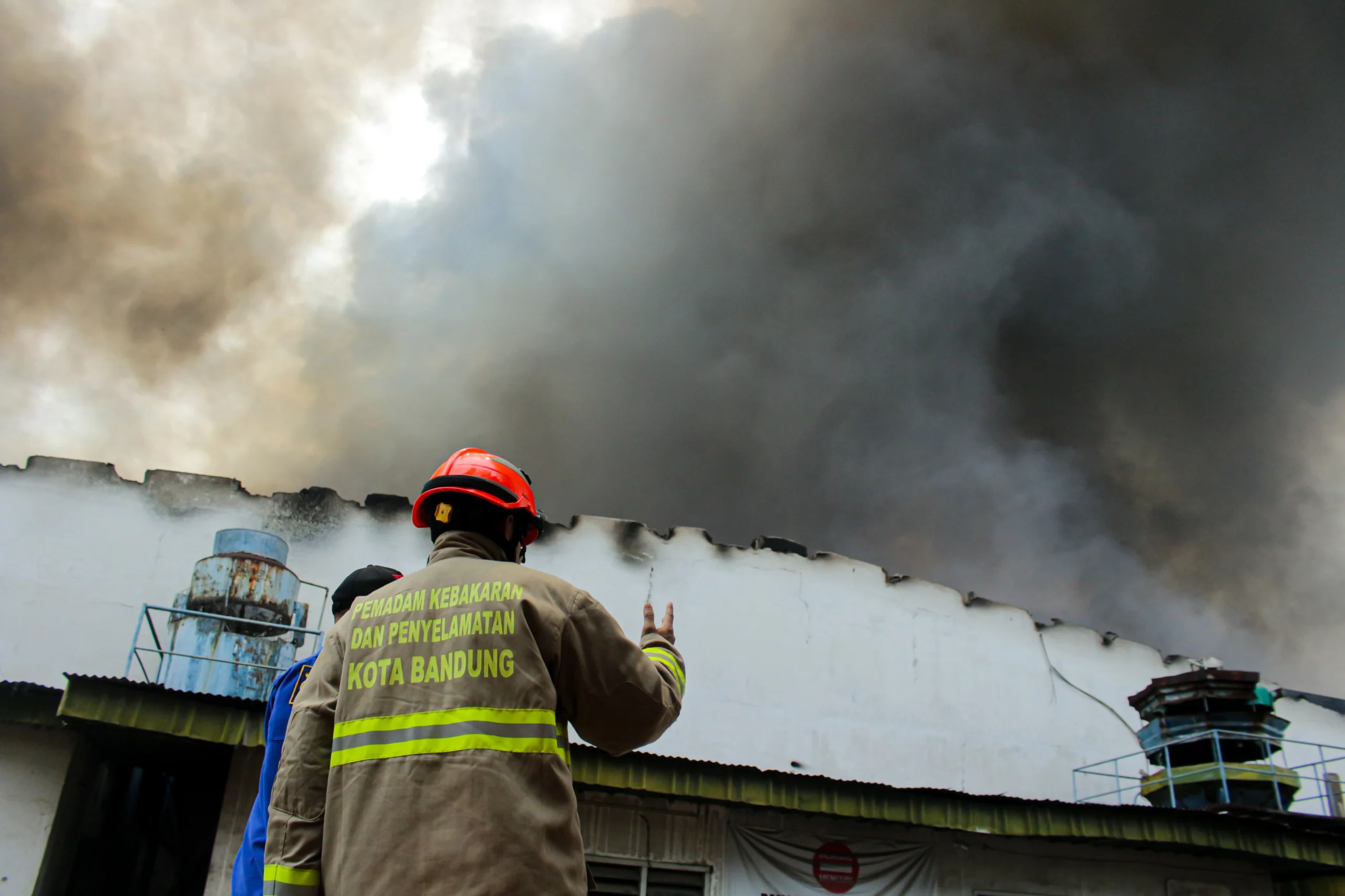 Petugas Diskar PB Kota Bandung berkoordinasi saat pemadam api di Gudang PT. Kasta Timbul, Cipadung, Kota Bandung (Pandu Muslim / Jabar Ekspres)