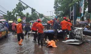Petugas gabungan saat mengevakuasi papan reklame yang roboh di Simpang Taman Corat-coret, Kota Bogor, Kamis (30/11).