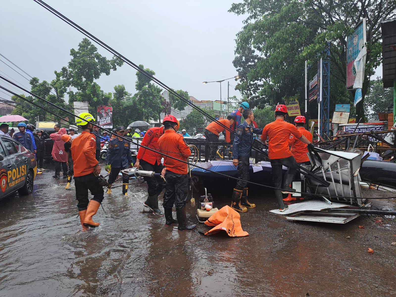 Petugas gabungan saat mengevakuasi papan reklame yang roboh di Simpang Taman Corat-coret, Kota Bogor, Kamis (30/11).