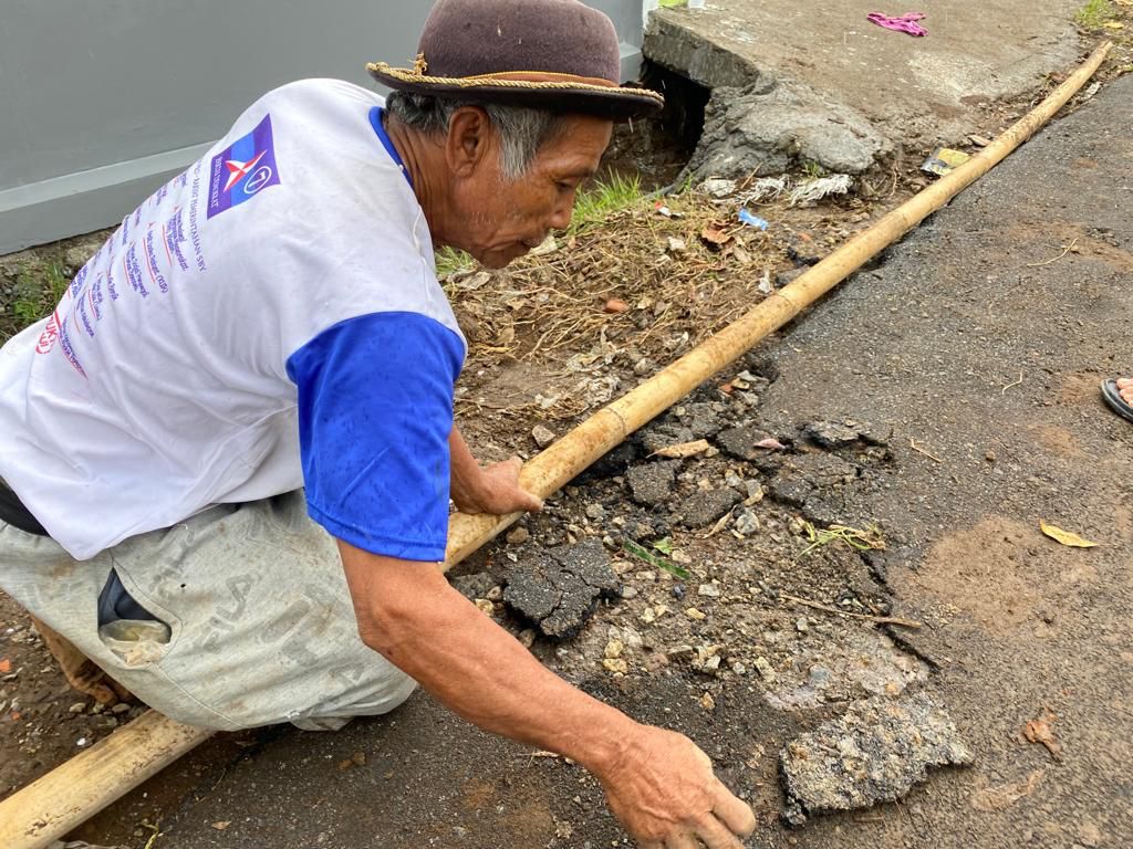 Warga Kampung Kiara Lawang kuliti aspal yang rusak kembali, padahal satu pekan baru diperbaiki melalui pokir DPRD KBB. Senin (4/12). Foto Jabarekspres