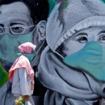 Ilustrasi: Seorang wanita di Kota Bandung mengenakan masker saat ke luar rumah di masa Covid-19.