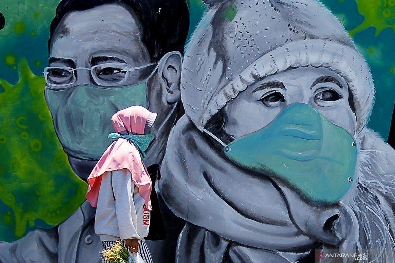 Ilustrasi: Seorang wanita di Kota Bandung mengenakan masker saat ke luar rumah di masa Covid-19.