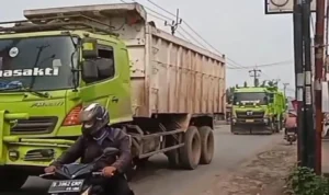 Sejumlah truk tambang masih melintasi Jalan Parung Panjang diluar jam operasional.