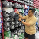 Muhammad Ilham Maulana Pengusaha Topi Custom saat memperlihatkan topi yang akan dicustom untuk para pemesan di rumah produksinya di Desa Cigondewah Hilir, Kecamatan Margaasih, Kabupaten Bandung, Jumat (8/12/2023). Foto Agi Jabar Ekspress
