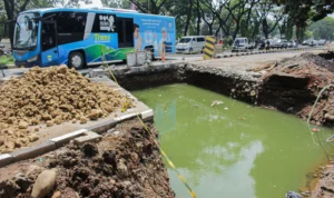 Kendaraan melintas di samping proyek cross drain (perbaikan drainase) agar tidak banjir di kawasan Gedebage, Jalan Soekarno Hatta, Kota Bandung.