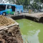 Kendaraan melintas di samping proyek cross drain (perbaikan drainase) agar tidak banjir di kawasan Gedebage, Jalan Soekarno Hatta, Kota Bandung.