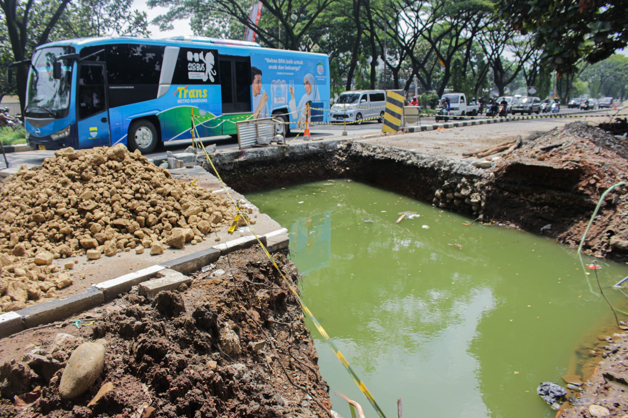 Kendaraan melintas di samping proyek cross drain (perbaikan drainase) agar tidak banjir di kawasan Gedebage, Jalan Soekarno Hatta, Kota Bandung.