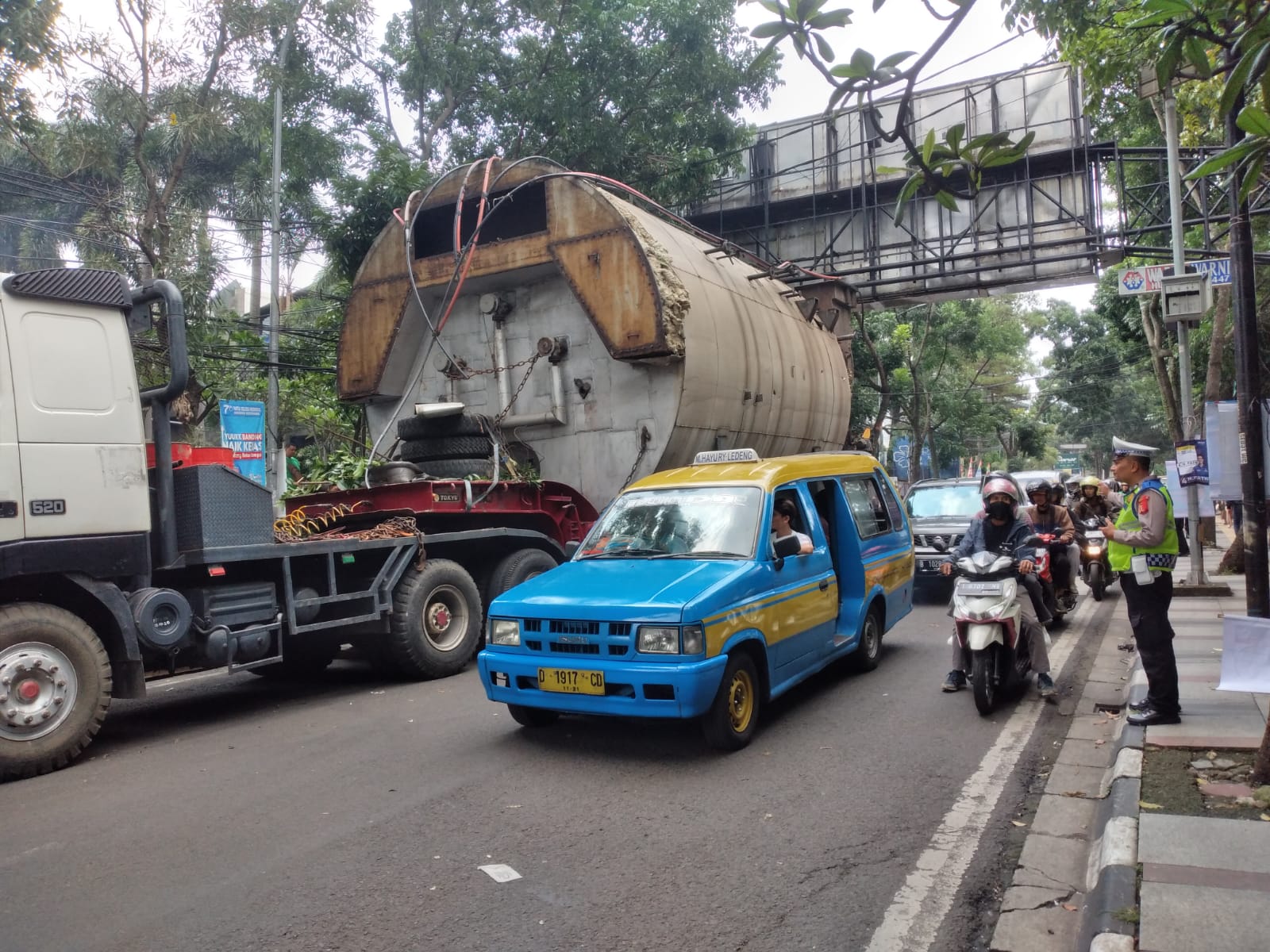 Petugas kepolisian nampak mengatur lalu lintas di samping truk pengangkut mesin pengolah batu bara yang nyangkut di Jalan Dr. Setiabudi / Hendrik Muchlison