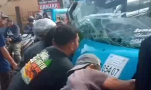 Angkot Cibadak-Cisaat yang mengalami kecelakaan di Cibadak, Kabupaten Sukabumi saat dievakuasi warga (30/1).
