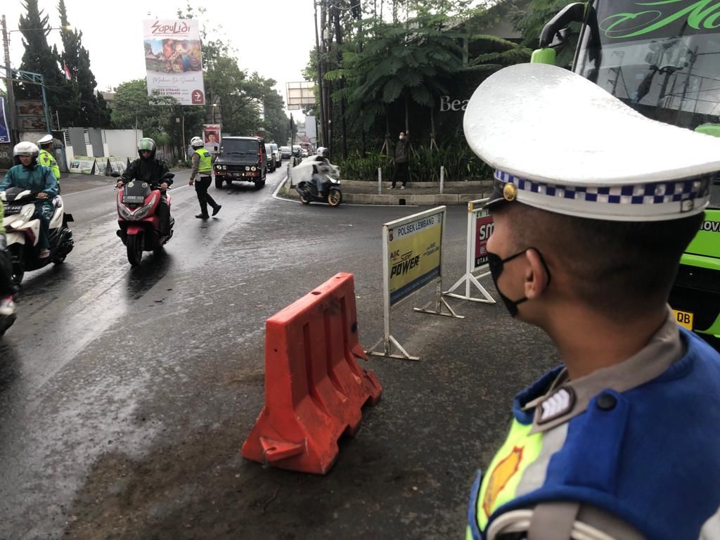 Petugas kepolisian saat melakukan rekayasa lalu lintas dengan skema one way di persimpangan Beatrix Lembang, KBB, Selasa (2/1).
