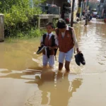 Anak-anak SD saat menerjang banjir yang terjadi di Kampung Bojongasih, Dayeuhkolot, Kabupaten Bandung, Senin (8/1).